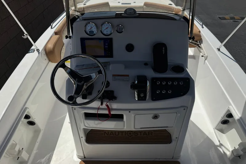 Slide: The Image of 2024 NauticStar 211 Hybrid boat dashboard with steering wheel and control panel. - 28