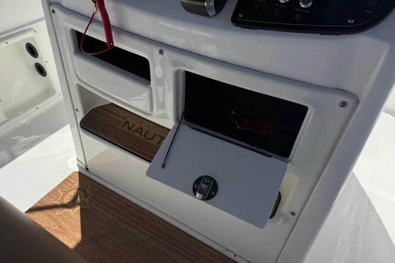 Slide: The Image of 2024 NauticStar 211 Hybrid boat console with storage compartments and wood accents. - 30