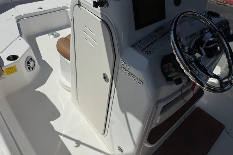 Slide: The Image of 2024 NauticStar 211 Hybrid boat interior with steering wheel and seating area. - 32