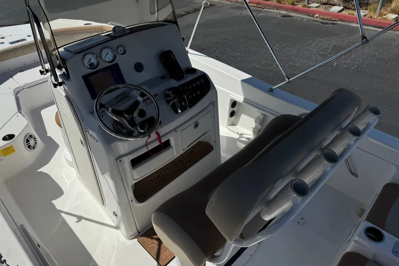 Slide: The Image of 2024 NauticStar 211 Hybrid boat cockpit with steering wheel, gauges, and seating. - 27
