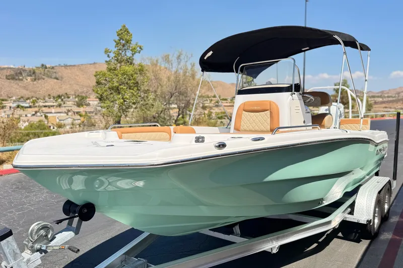 Slide: The Image of 2024 NauticStar 211 Hybrid boat on trailer, featuring sleek design and canopy. - 3