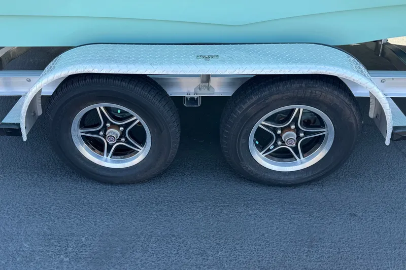 Slide: The Image of Trailer wheels of a 2024 NauticStar 211 Hybrid boat on a diamond plate fender. - 34