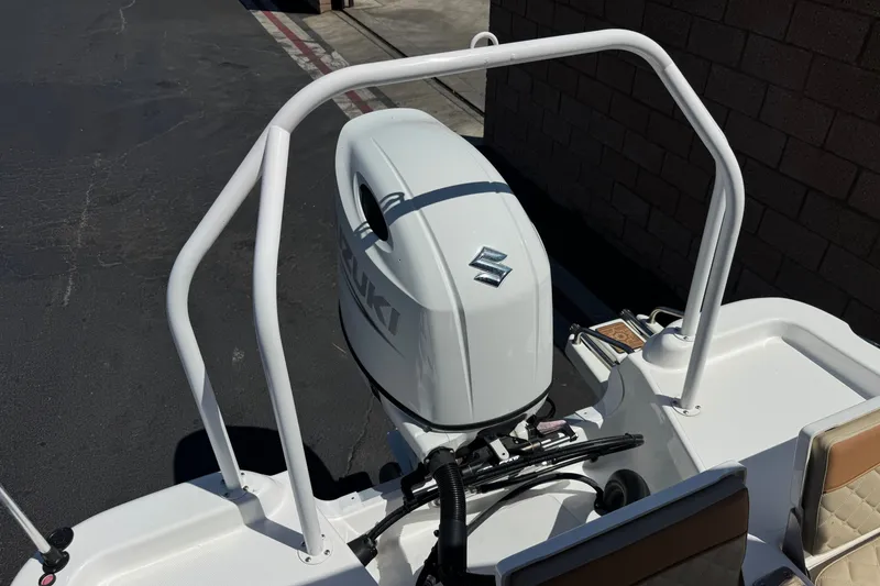 Slide: The Image of 2024 NauticStar 211 Hybrid boat with Suzuki outboard motor, docked in a marina. - 25