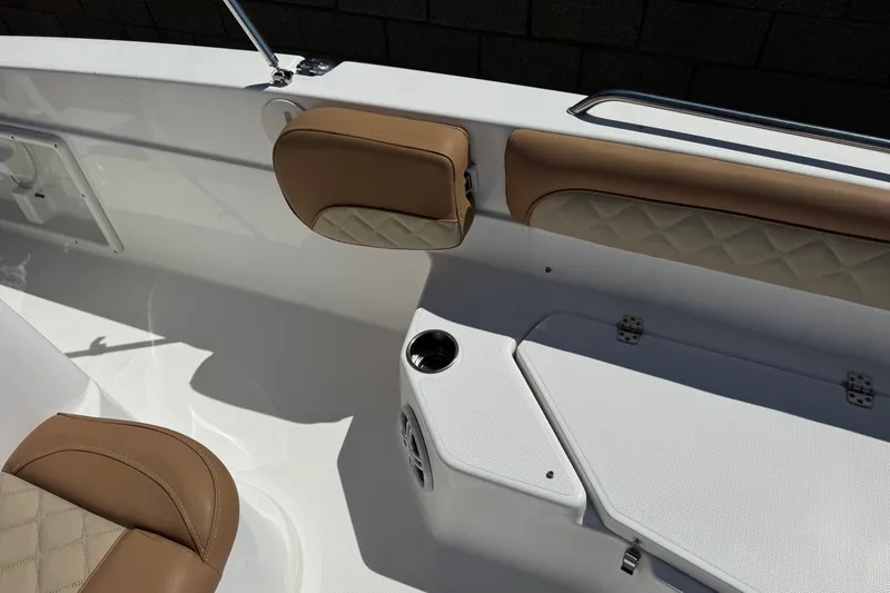 Slide: The Image of 2024 NauticStar 211 Hybrid boat interior with tan cushioned seating and cup holder. - 15