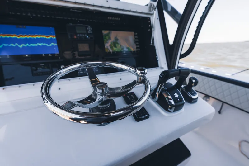 Slide: The Image of Cockpit of 2015 SeaHunter 37 Tournament boat with steering wheel and navigation screens. - 37