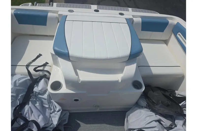 Slide: The Image of 2013 Bayliner 195 Bowrider boat interior with white and blue seating and cup holders. - 21