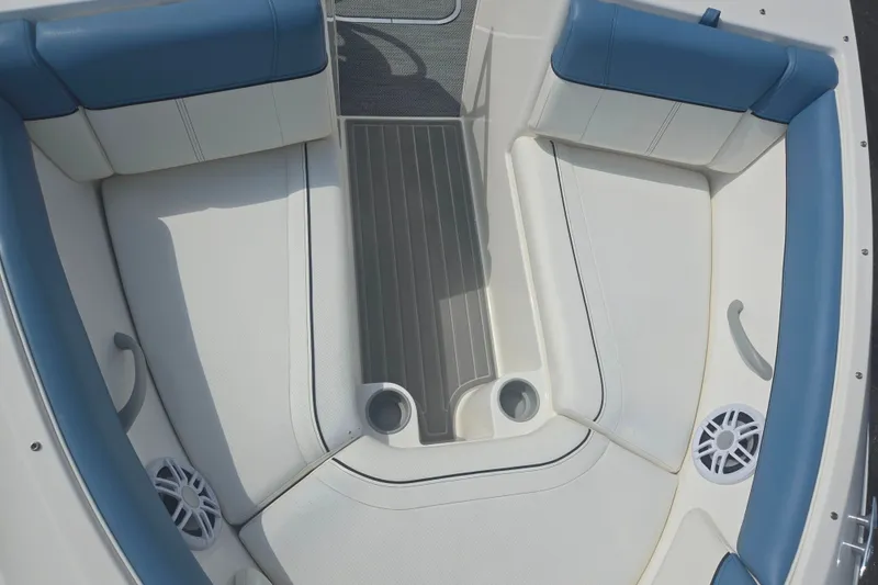 Slide: The Image of 2013 Bayliner 195 Bowrider interior with blue and white seating, cup holders, and speakers. - 17
