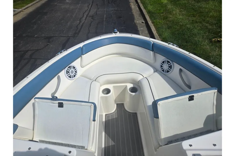 Slide: The Image of 2013 Bayliner 195 Bowrider interior with blue and white seating, cup holders, and speakers. - 16