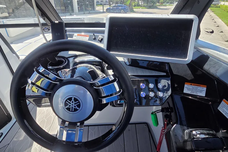 Slide: The Image of 2023 Yamaha Boats 222XD dashboard with steering wheel and touchscreen display. - 13