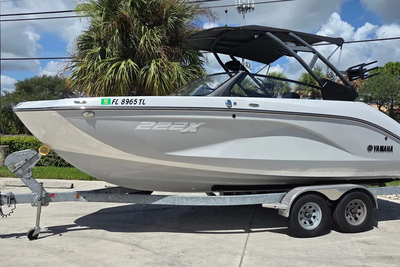The Image of 2023 Yamaha Boats 222XD on trailer, parked outdoors under a clear sky. - 1
