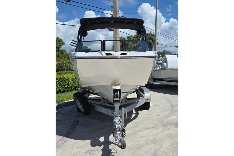Slide: The Image of 2023 Yamaha Boats 222XD on trailer, parked outdoors under a clear blue sky. - 2