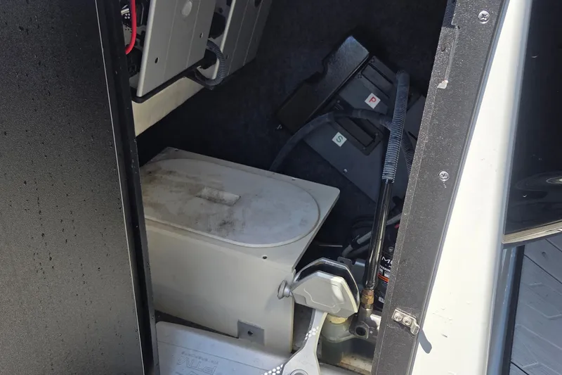 Slide: The Image of 2023 Yamaha Boats 222XD storage compartment with equipment and wiring visible. - 16