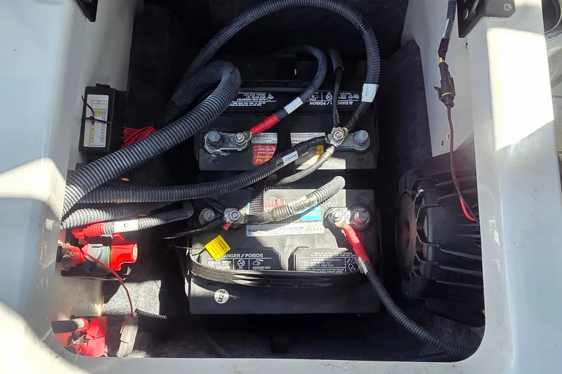Slide: The Image of Battery compartment of 2023 Yamaha Boats 222XD with connected cables. - 12