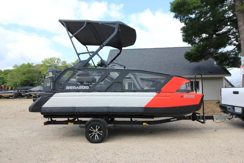 Slide: The Image of 2022 Sea-Doo Switch Sport 18 pontoon boat on trailer, parked outdoors. - 1