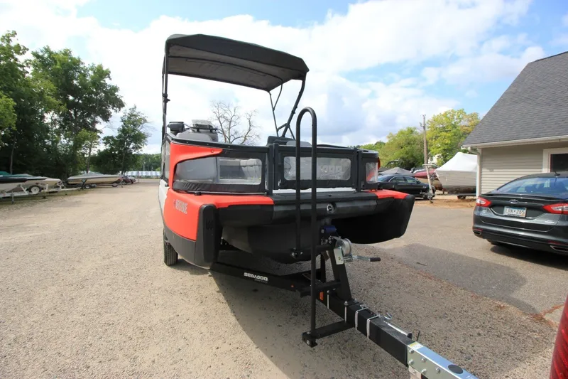 Slide: The Image of 2022 Sea-Doo Switch Sport 18 on trailer, parked outdoors near other vehicles. - 5
