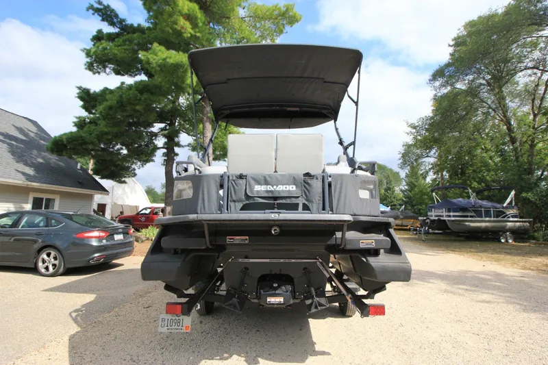 Slide: The Image of 2022 Sea-Doo Switch Sport 18 pontoon boat parked outdoors, rear view. - 2