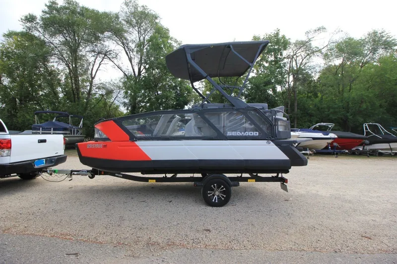 Slide: The Image of 2022 Sea-Doo Switch Sport 18 on trailer, parked outdoors with trees in background. - 3