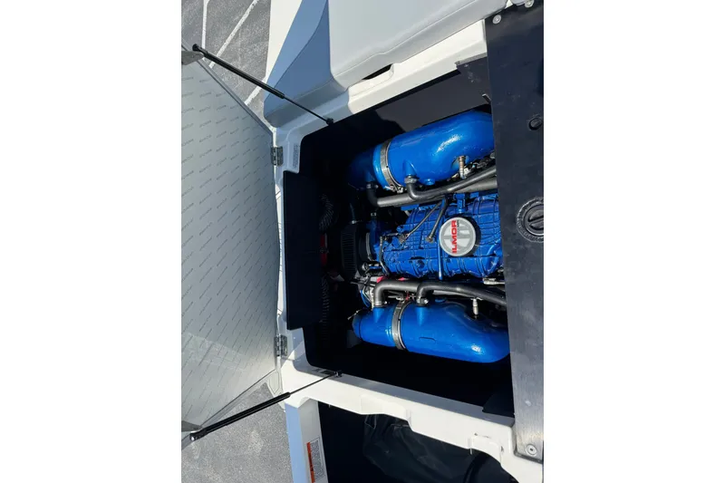 Slide: The Image of 2022 MasterCraft NXT22 engine compartment with blue components and open hatch. - 12