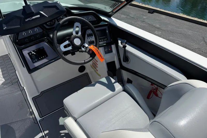 Slide: The Image of 2022 MasterCraft NXT22 boat cockpit with steering wheel and control panel. - 9