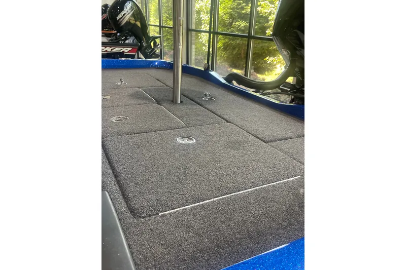 Slide: The Image of 2021 Ranger Z518 boat deck with carpeted storage compartments and visible motor. - 8