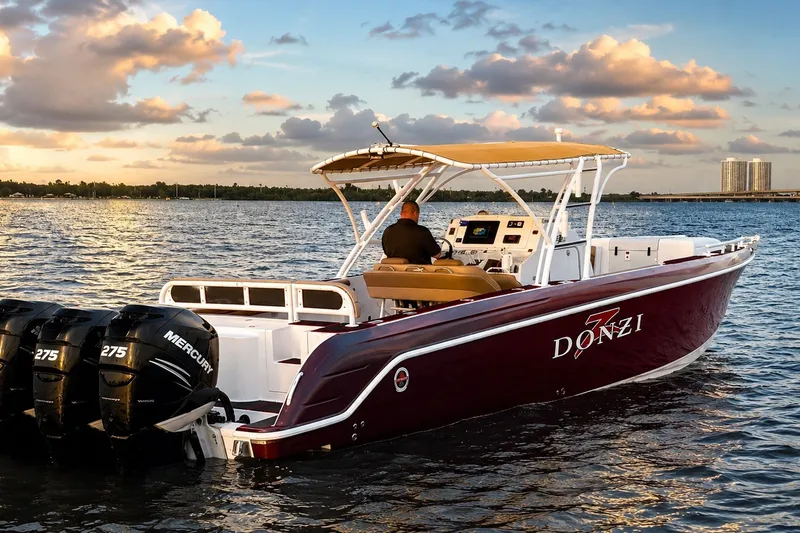 Slide: The Image of 2006 Donzi 38 ZFX Cuddy boat on water at sunset, featuring Mercury engines. - 15