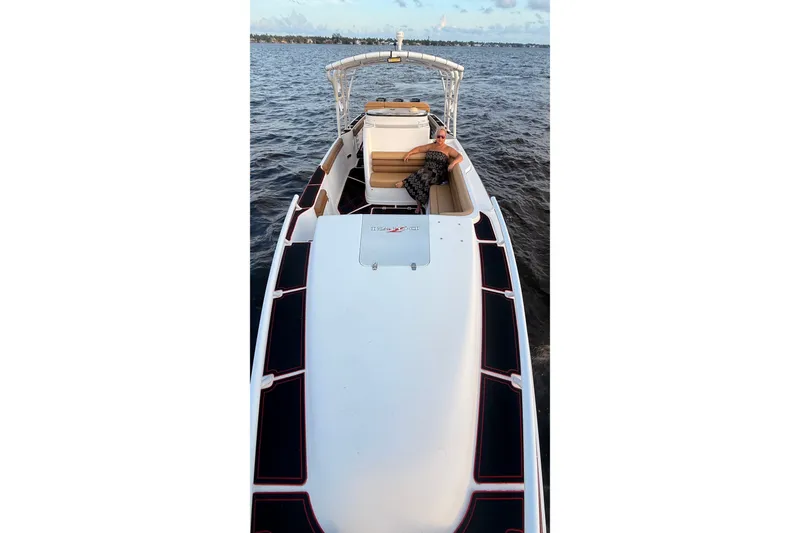 Slide: The Image of 2006 Donzi 38 ZFX Cuddy boat cruising on open water with a person relaxing onboard. - 30