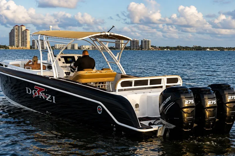 Slide: The Image of 2006 Donzi 38 ZFX Cuddy boat cruising on water with city skyline in background. - 20