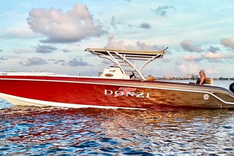 Slide: The Image of 2006 Donzi 38 ZFX Cuddy boat on water at sunset, showcasing sleek design. - 28