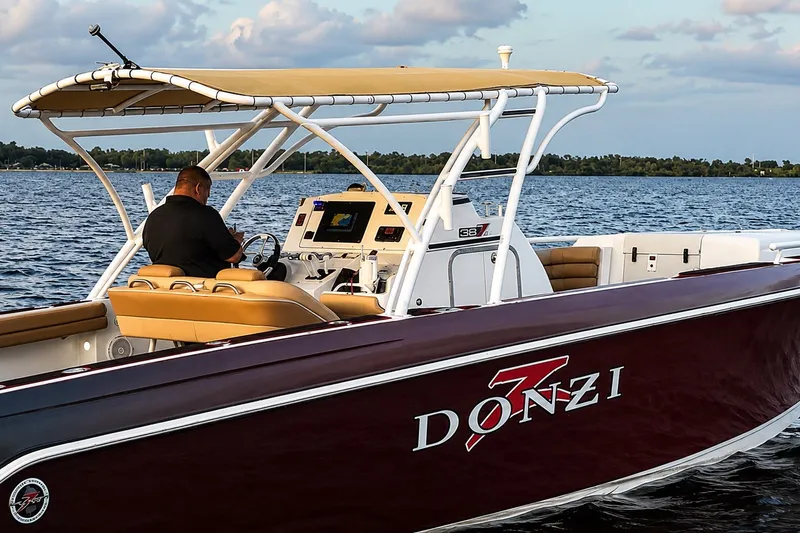Slide: The Image of 2006 Donzi 38 ZFX Cuddy boat cruising on a lake with a person at the helm. - 17