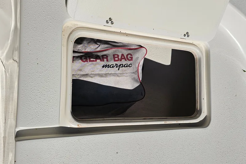 Slide: The Image of Storage compartment on a 2016 Carolina Skiff 258 DLV with a Marpac gear bag inside. - 15