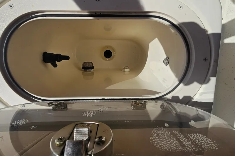 Slide: The Image of Livewell compartment of a 2016 Carolina Skiff 258 DLV boat, featuring a secure latch. - 14
