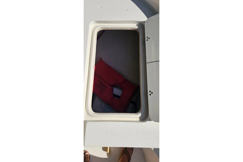 Slide: The Image of Open storage compartment on 2016 Carolina Skiff 258 DLV boat with life jacket inside. - 17
