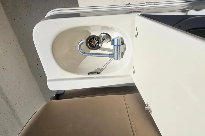 Slide: The Image of 2016 Carolina Skiff 258 DLV boat sink with faucet and storage compartment. - 13