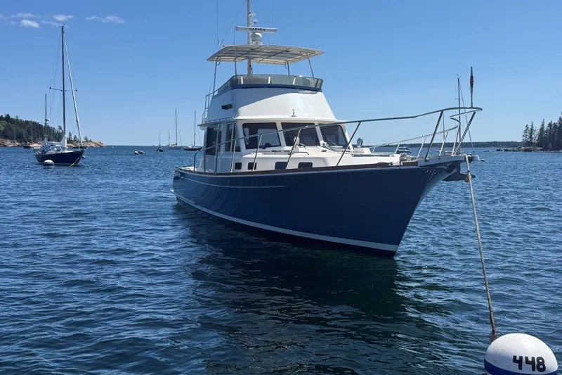 Slide: The Image of York's Marine 46 Flybridge Cruiser, 2013, anchored in a scenic coastal bay. - 5