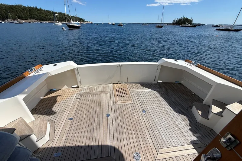 Slide: The Image of York's Marine 46 Flybridge Cruiser 2013, spacious deck overlooking serene waters and anchored boats. - 12