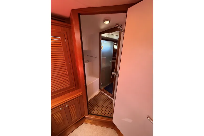 Slide: The Image of Interior of 2013 York's Marine 46 Flybridge Cruiser, featuring wooden cabinetry and bathroom entrance. - 53