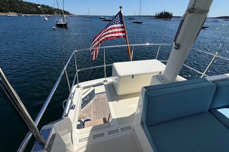 Slide: The Image of York's Marine 46 Flybridge Cruiser, 2013, with American flag, on serene water. - 24