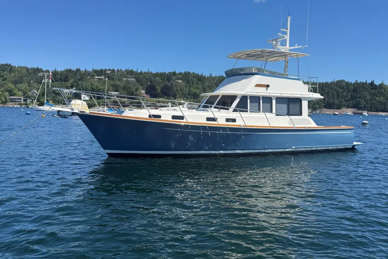 Slide: The Image of 2013 York's Marine 46 Flybridge Cruiser on serene water with forested shoreline. - 2