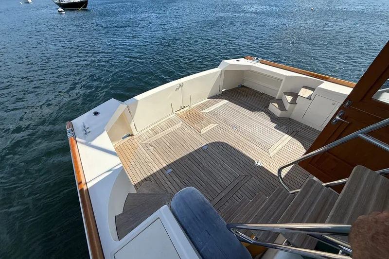 Slide: The Image of York's Marine 46 Flybridge Cruiser 2013, spacious deck with wooden flooring, docked on water. - 15