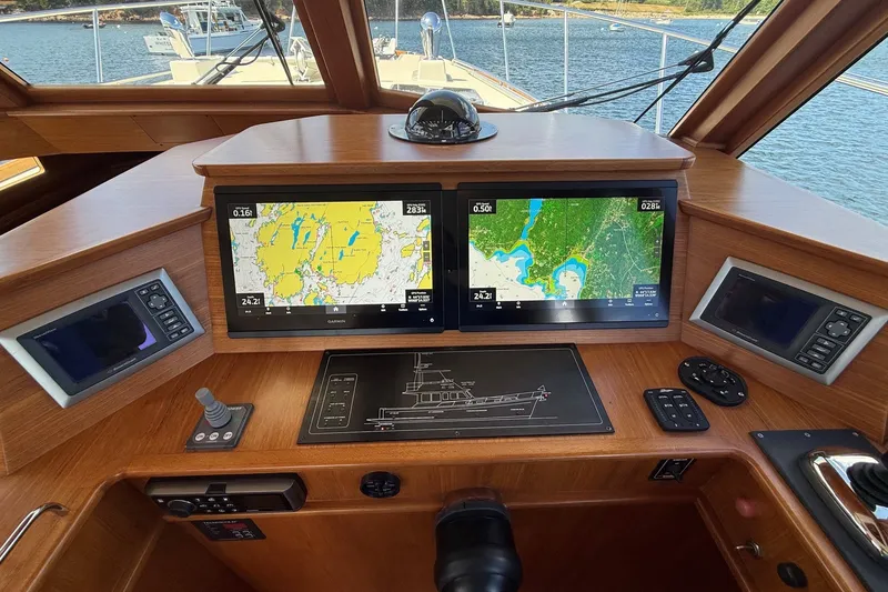 Slide: The Image of Helm of 2013 York's Marine 46 Flybridge Cruiser with navigation screens and controls. - 39