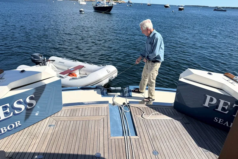Slide: The Image of Man on York's Marine 46 Flybridge Cruiser, 2013, managing dinghy on calm water. - 27