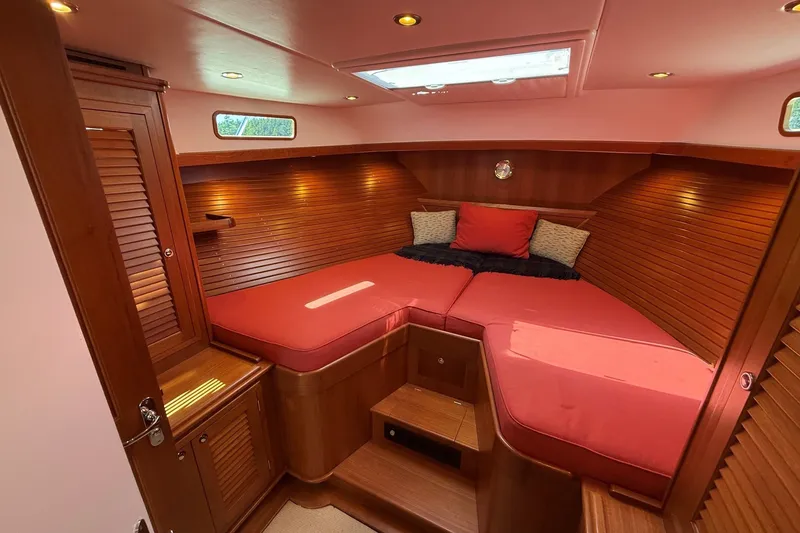 Slide: The Image of Luxurious cabin interior of 2013 York's Marine 46 Flybridge Cruiser with red bedding and wood finish. - 55