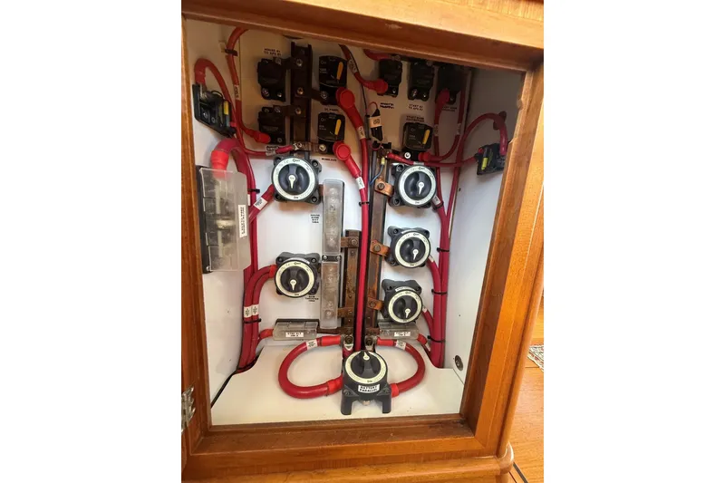 Slide: The Image of Electrical panel of a 2013 York's Marine 46 Flybridge Cruiser with red wiring and switches. - 59