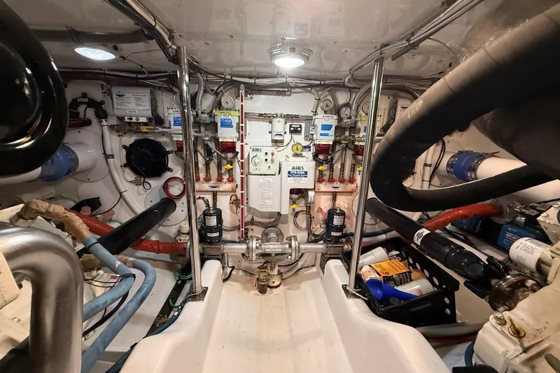Slide: The Image of Engine room of 2013 York's Marine 46 Flybridge Cruiser, showcasing complex machinery and piping. - 64