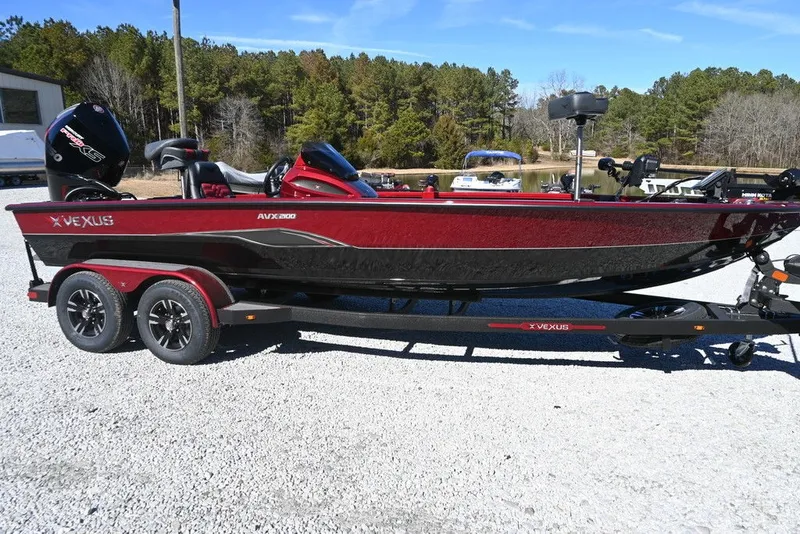 The Image of A red 2026 Vexus AVX 2100 boat on a trailer in a gravel lot. - 1