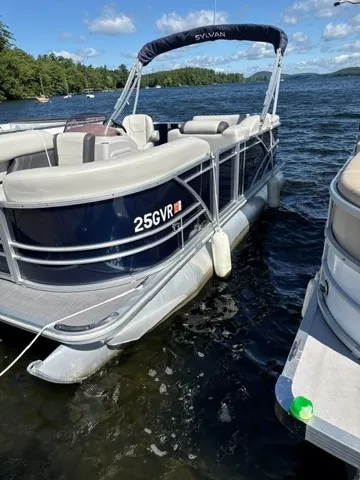 The Image of A 2023 Sylvan MIRAGE 818 CRS pontoon boat docked. It features a blue exterior. - 3