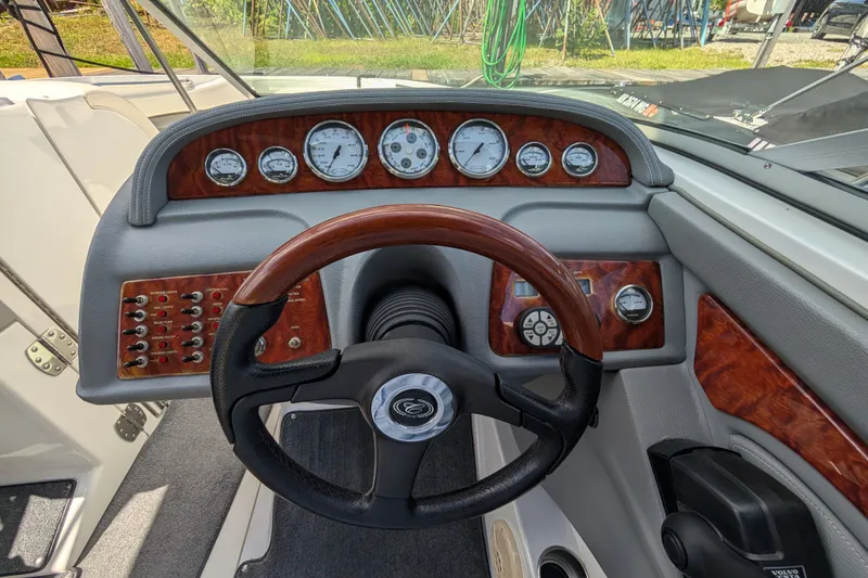 Slide: The Image of Steering wheel and dashboard of a 2006 Cobalt 262 boat with wood accents. - 4