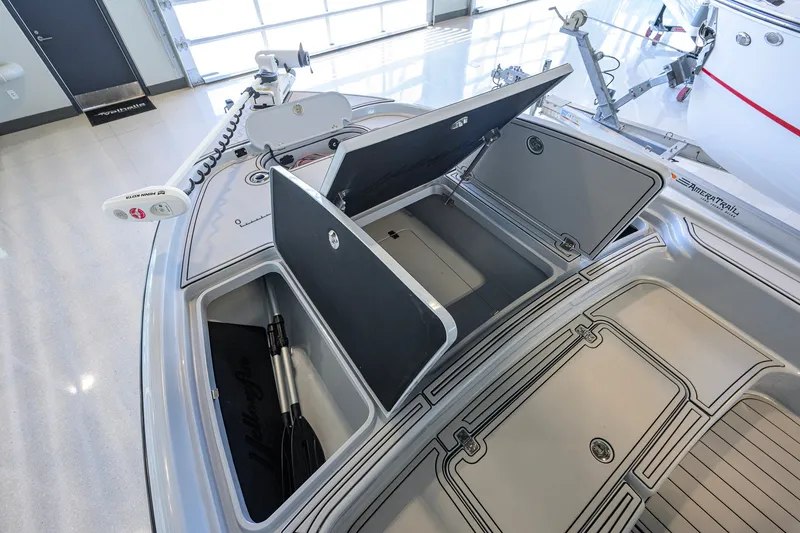 Slide: The Image of 2017 Yellowfin 24 Bay CE boat with open storage compartments in a showroom. - 12