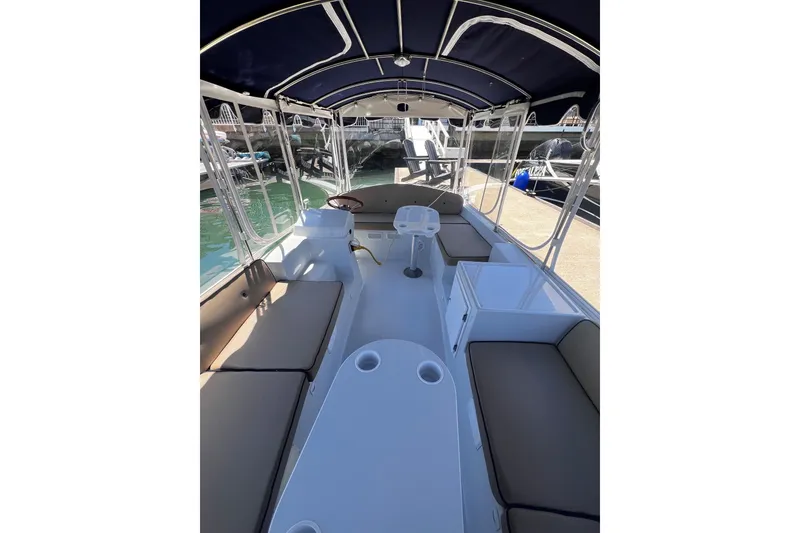 Slide: The Image of 2007 Duffy 21 Old Bay boat interior with seating and canopy, docked at marina. - 5