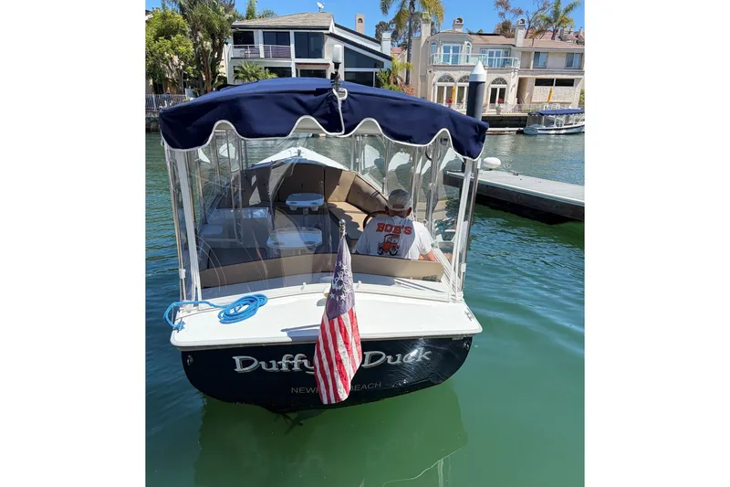 Slide: The Image of 2007 Duffy 21 Old Bay boat docked, featuring canopy and American flag. - 2